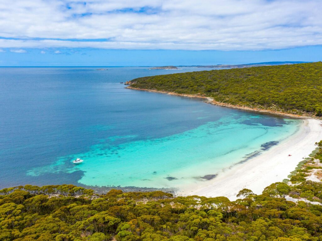 a white sand beach with clear blue waters in the memory cove wilderness protection area